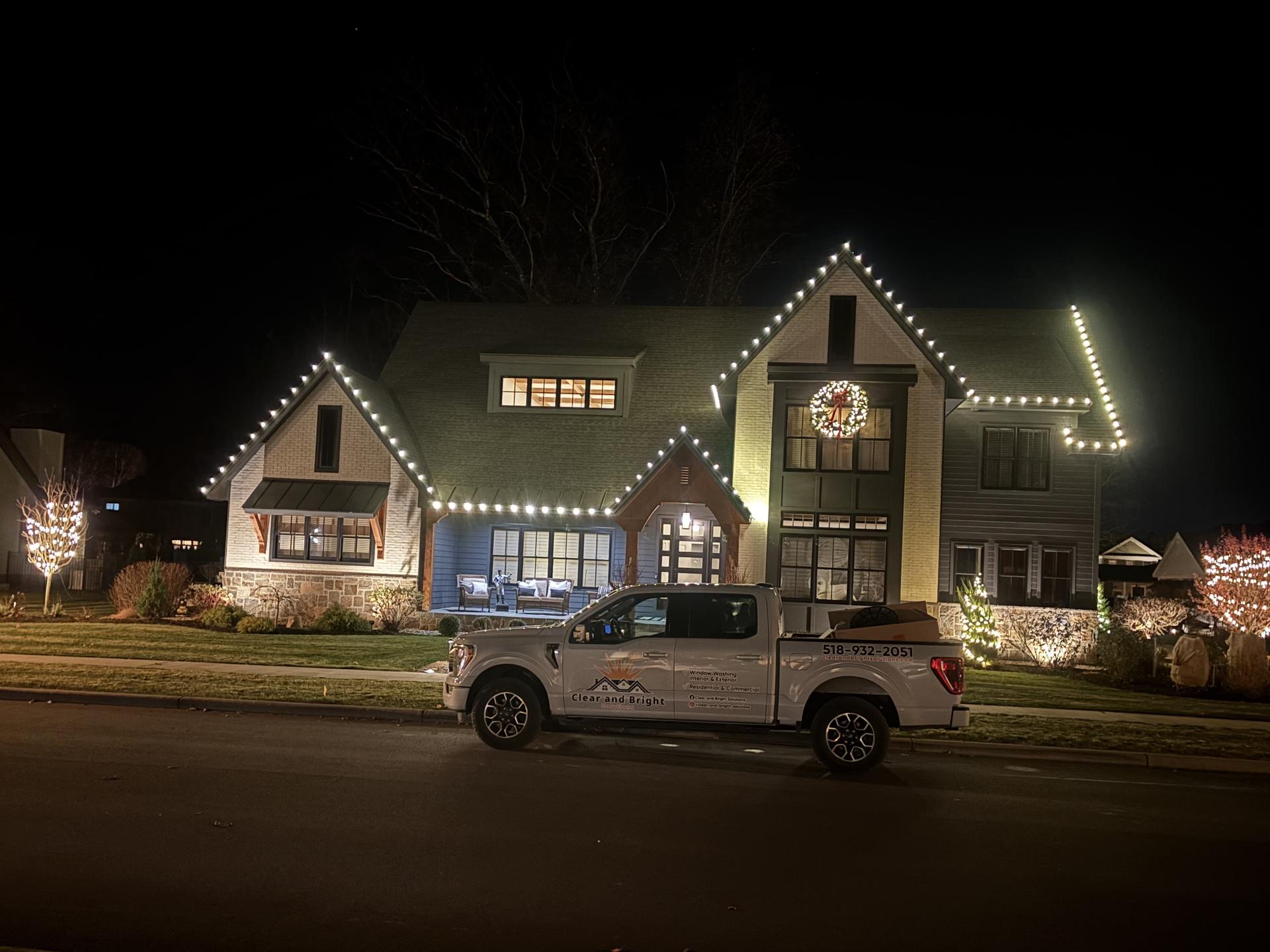 Your Company truck in front of a holiday lit home